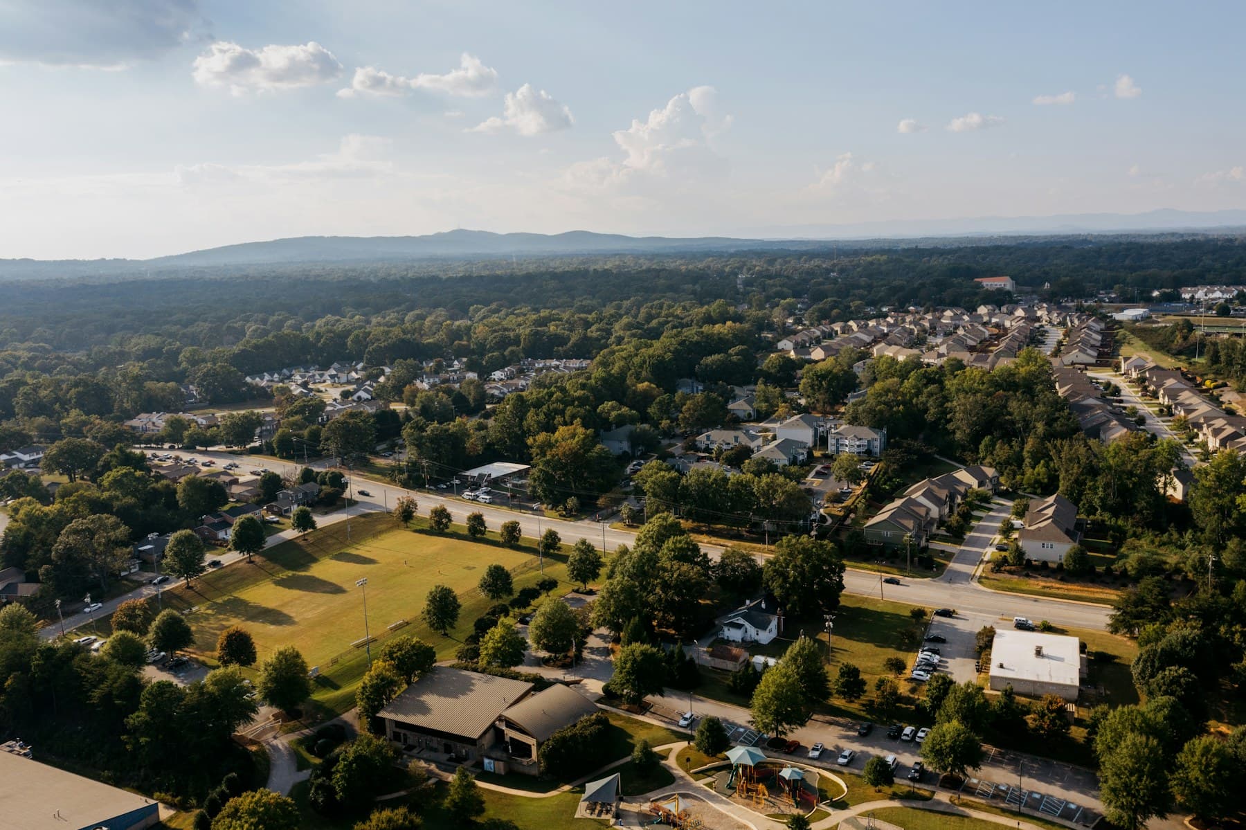 Aerial view of a residential community with homes, shared green space, and surrounding streets